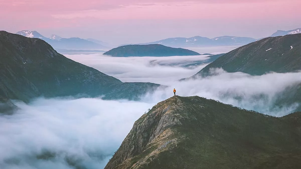 Uomo in cima ad un monte che guarda il tramonto norvegese - IS: 1333450753