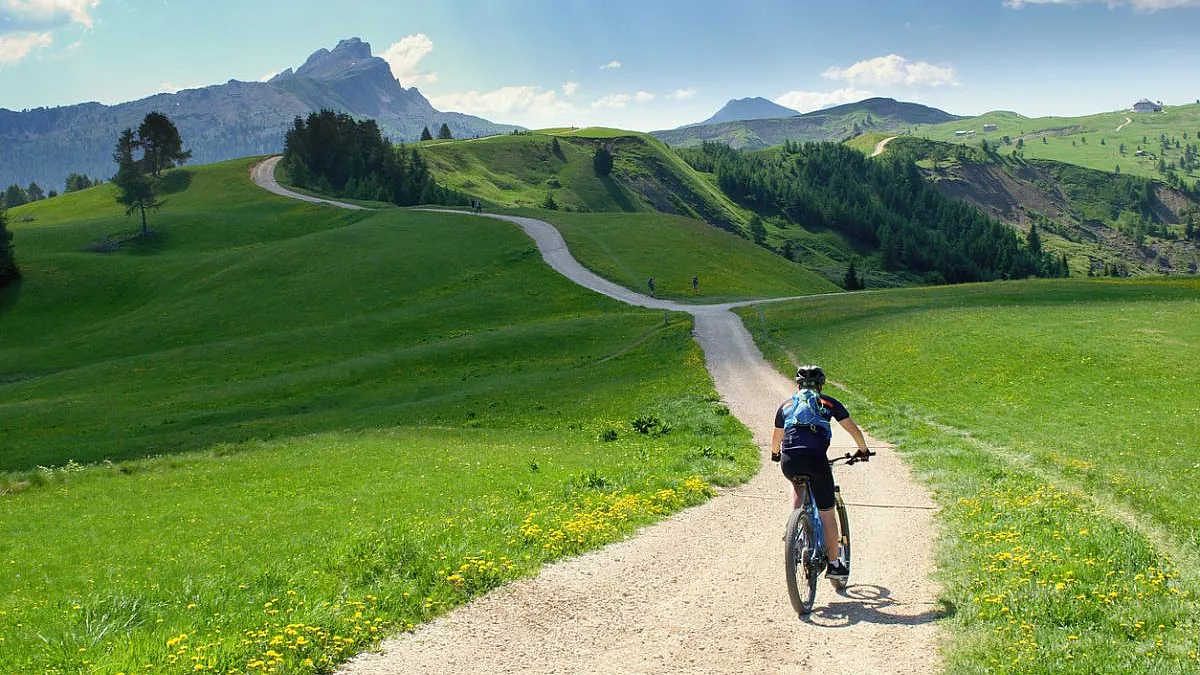 Biker su bicicletta in un paesaggio delle Dolomiti